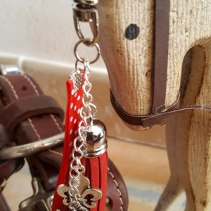 porte-clef mousqueton. Galon rouge à poids blancs, galon argenté en velours rouge, charm breloque fleur de lys . Longueur totale environ 14 cm. 