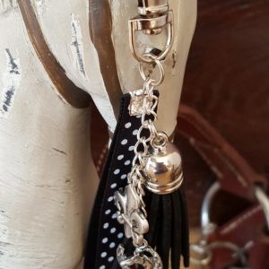 Porte clef mousqueton . Galon noir à poids blancs, fleur de lys, pompon noir en velours. Longueur totale 14 cm.