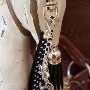 Porte clef mousqueton . Galon noir à poids blancs, fleur de lys, pompon noir en velours. Longueur totale 14 cm.