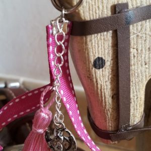 Porte-clef anneau 1,5 cm de diamètre. Galon gros grain rose foncé, pompon en soie rose clair, breloque charm papillon. longueur totale environ 10 cm