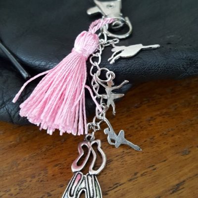 Porte-clefs ou bijoux de sac. attache mousqueton , pompon rose en soie, trois petites breloques danseuses terminé par une paire de chausson de danse. Longueur totale environ 12 cm