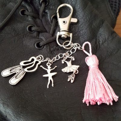 Porte-clef ou bijoux de sac comprenant une attache mousqueton , un pompon rose en soie, trois breloques , tutu avec ces chausson, une paire de chausson de danse et d'une petite danseuse. Longueur totale, environ 12 cm