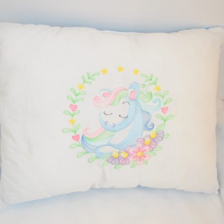 Coussin de décoration brodé d'une licorne encadrée par de jolies fleurs