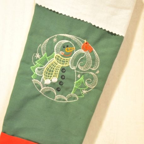 Gros plan  d un bonhomme de neige sur tissu vert. Création artisanale Bébé Boutchou