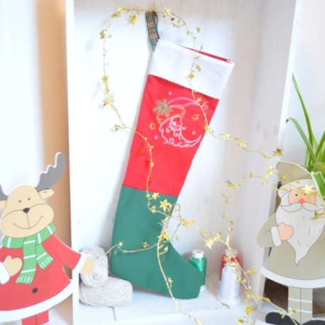 Chaussette de Noël brodée dune lune sur tissu rouge. Création artisanale