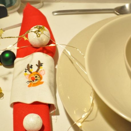 Gros plan. Suggestion de présentation. Broderie petite souris renne de Noël sur rond de serviette en tissu. Création artisanale Bébé Boutchou